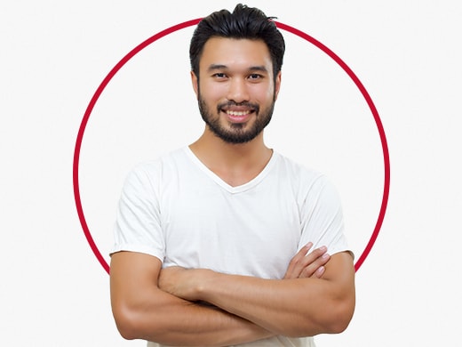 Homem jovem sorridente em pose confiante, vestindo uma camiseta cinza, feliz após o tratamento para micose de virilha Canesten