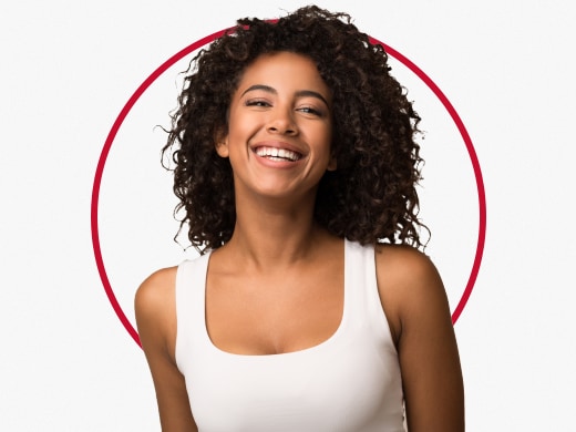 Mulher sorridente vestindo um top, feliz após o tratamento para pano branco Canesten